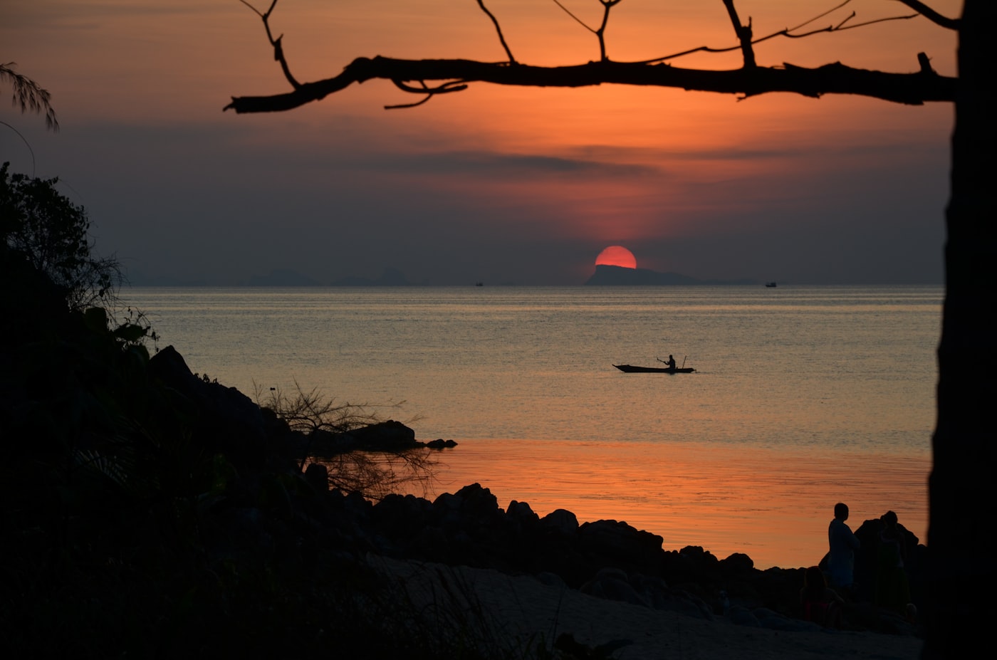 Sunset over the Gulf of Thailand from the west coast of Koh Phangan, with a fisherman silhouetted in a small boat